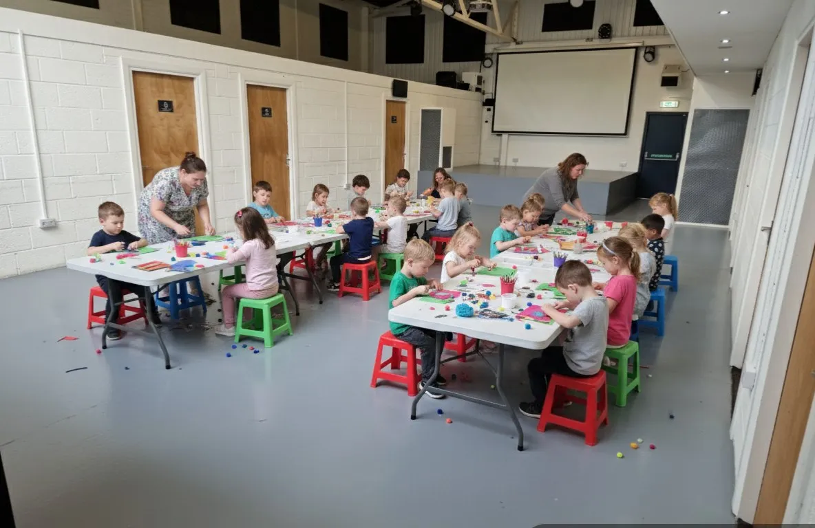 Children at tables during an arts and crafts session in the hall