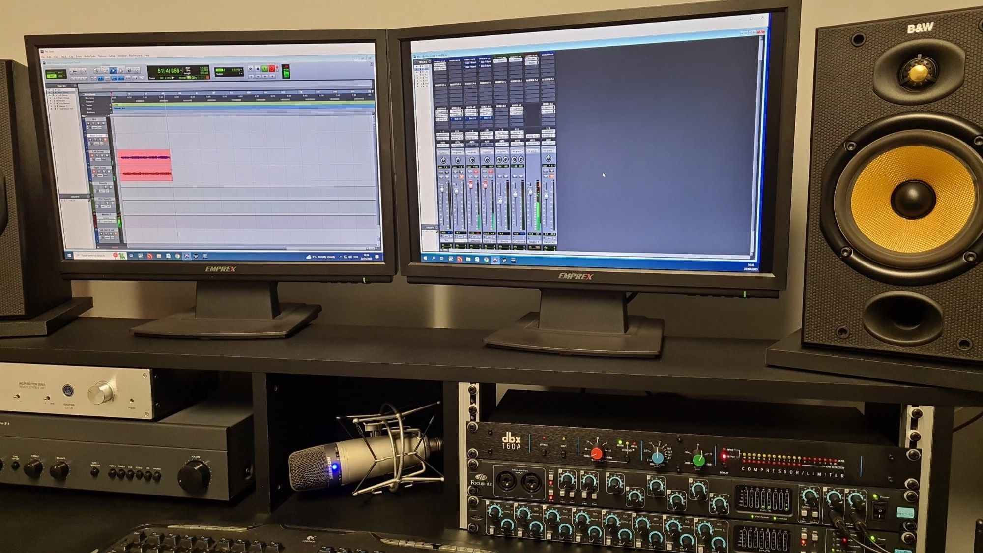 The recording studio desk with two screens, studio monitors and outboard gear